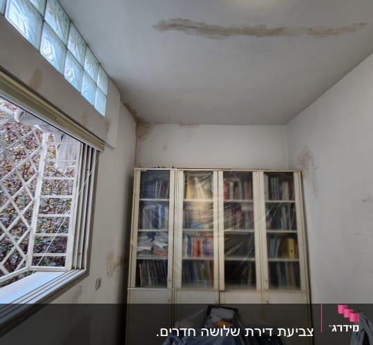 חדר עם קיר מתקלף, רהיטים מכוסים בניילון